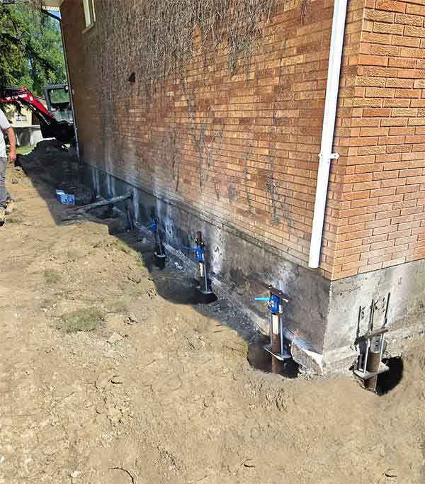 Helical piles installation for foundation of home.